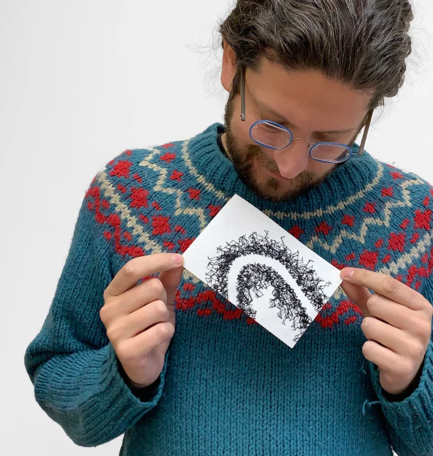 Jack Roberts holding a single picture created from black and white thread