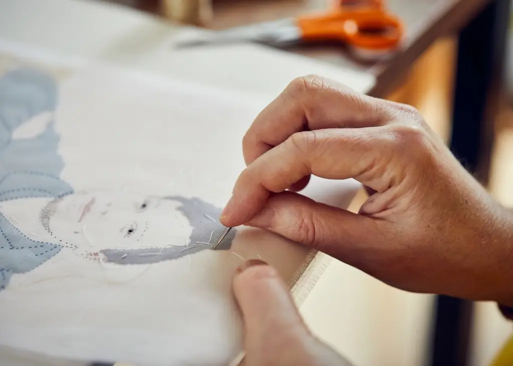 Emily Jo Gibbs hand stitching a portrait